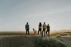 Back View of a Family Standing on Sand Dune looking at opportunities for land investment
