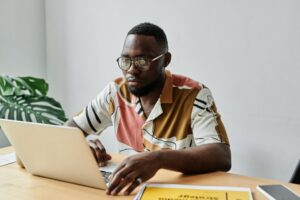 Close Up Photo of a Man Using Laptop When Searching Questions To Ask Before Buying Land