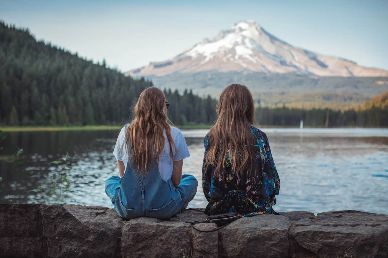 two women sitting on rock 