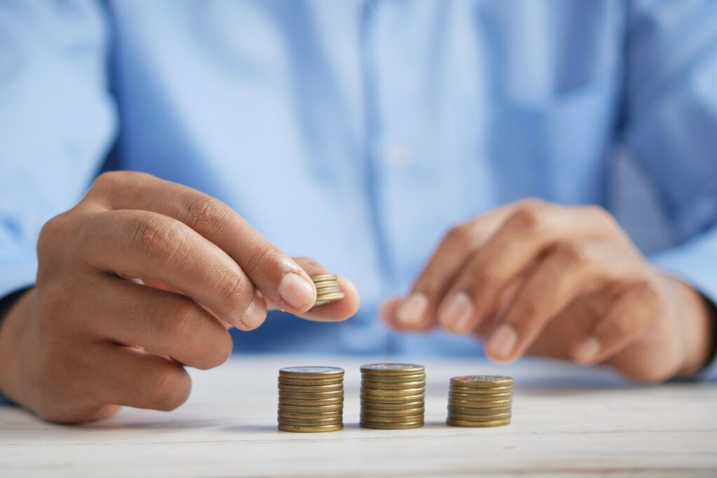 towfiqu-barbhuiya-jpqyfK7GB4w-unsplash-1024x683 man's hand adding a coin on top of a pile of coins